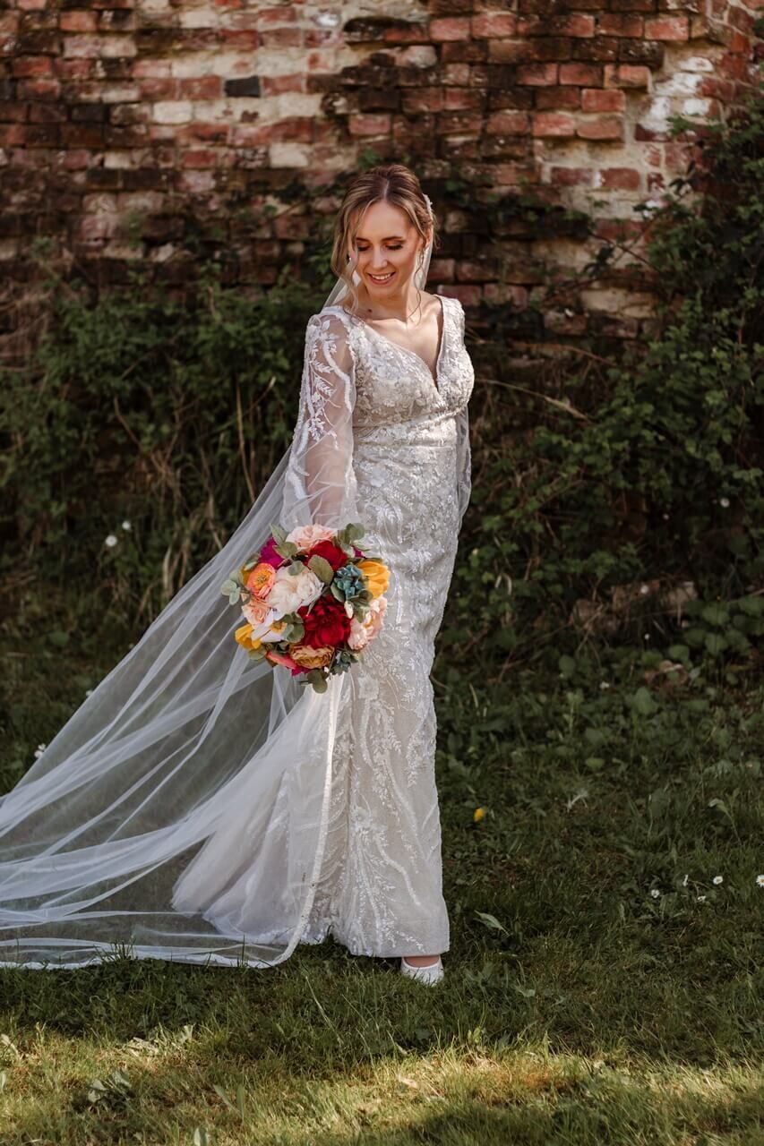 Mladenka Lucija s šarenim buketom od krep papira uz stari zid